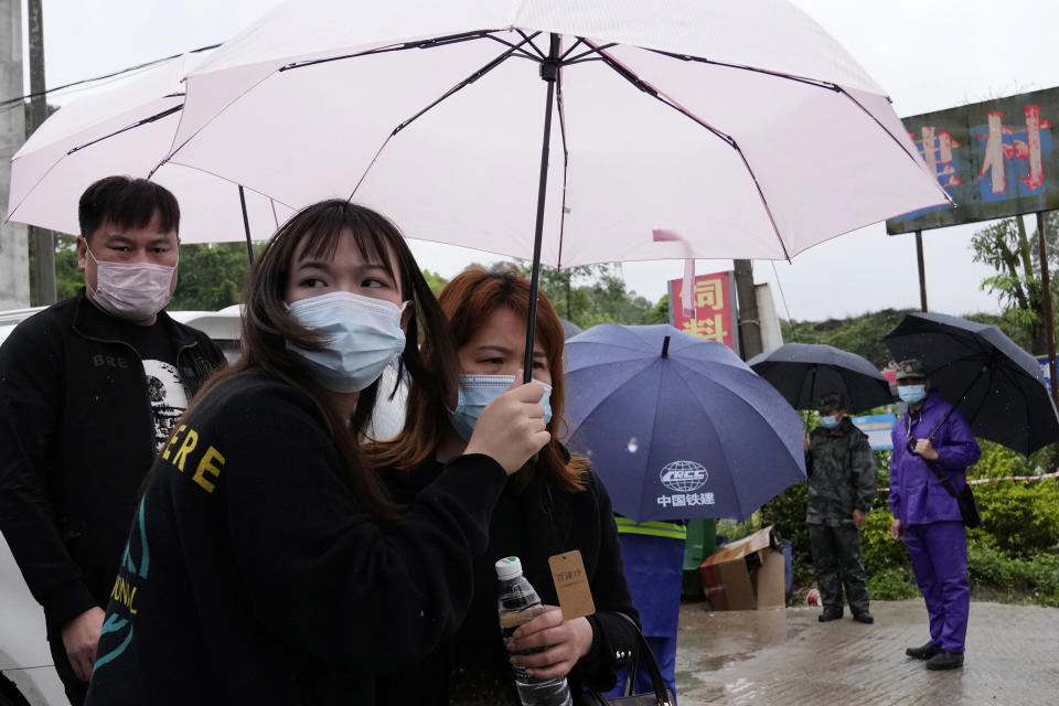 Relatives of passengers onboard the China Eastern Flight 5735 leave the village near the crash site on Wednesday, March 23, 2022, in southwestern China's Guangxi province. The search for clues into why a plane made an inexplicable dive and crashed into a mountain in southern China was suspended Wednesday as rain slicked the debris field and filled the red-dirt gash formed by the plane's fiery impact. (AP Photo/Ng Han Guan)