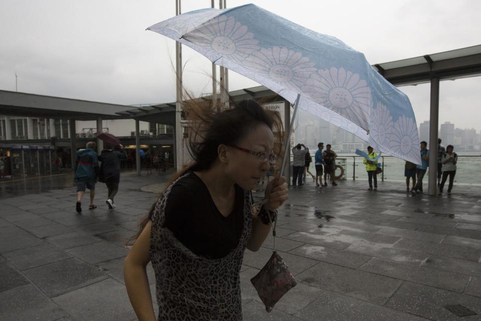 A woman braves gusty winds outside a shopping mall at Tsim Sha Tsui shopping district during Typhoon Usagi in Hong Kong September 22, 2013. Hong Kong was bracing on Sunday for this year's most powerful typhoon, with government meteorologists warning of severe flooding created by a double whammy of powerful winds and exceptionally high tides.REUTERS/Tyrone Siu (CHINA - Tags: ENVIRONMENT DISASTER)