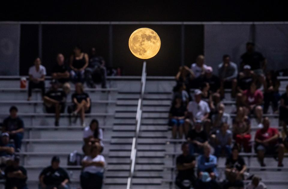 The final supermoon of 2023 iss seen rising beyond the visiting stands during the first quarter of their game at Shadow Hills High School in Indio, Calif., Friday, Sept. 29, 2023.