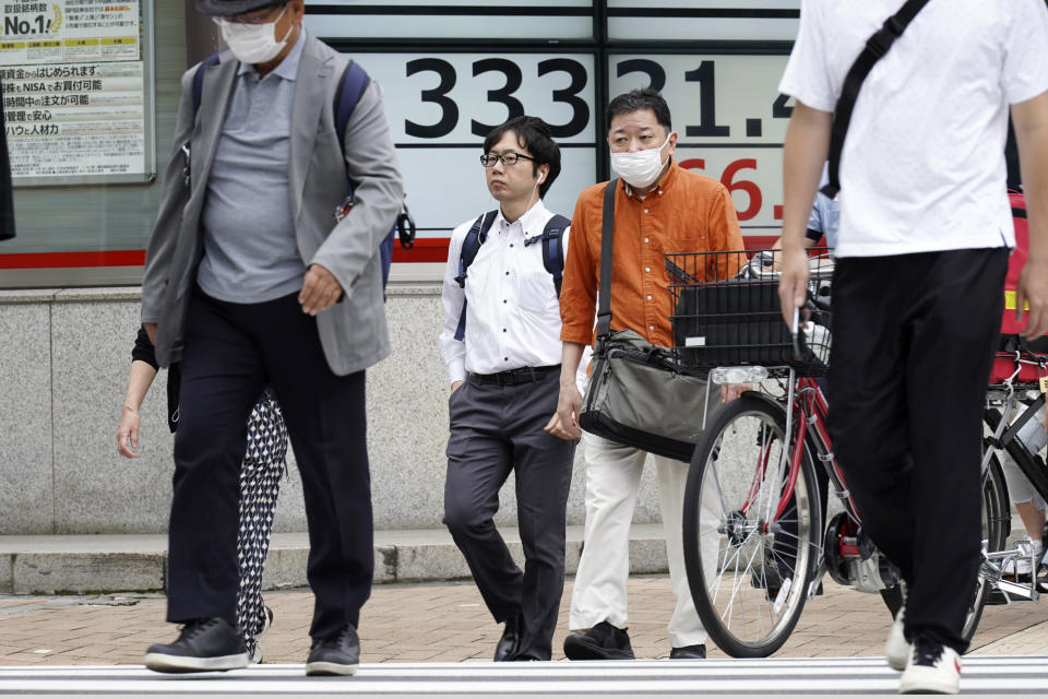 People walk in front of an electronic stock board showing Japan's Nikkei 225 index at a securities firm Friday, June 23, 2023, in Tokyo. Asian shares sank sharply Friday after several central banks around the world cranked interest rates higher in their fight against inflation.(AP Photo/Eugene Hoshiko)