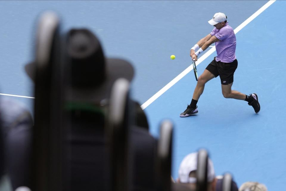 Casper Ruud of Norway plays a backhand return to Jenson Brooksby of the U.S. during their second round match at the Australian Open tennis championship in Melbourne, Australia, Thursday, Jan. 19, 2023. (AP Photo/Dita Alangkara)