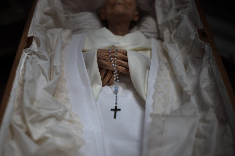 The body of an elderly person is prepared inside a coffin for her funeral at a morgue in Barcelona, Spain, Nov. 5, 2020. The image was part of a series by Associated Press photographer Emilio Morenatti that won the 2021 Pulitzer Prize for feature photography. (AP Photo/Emilio Morenatti)