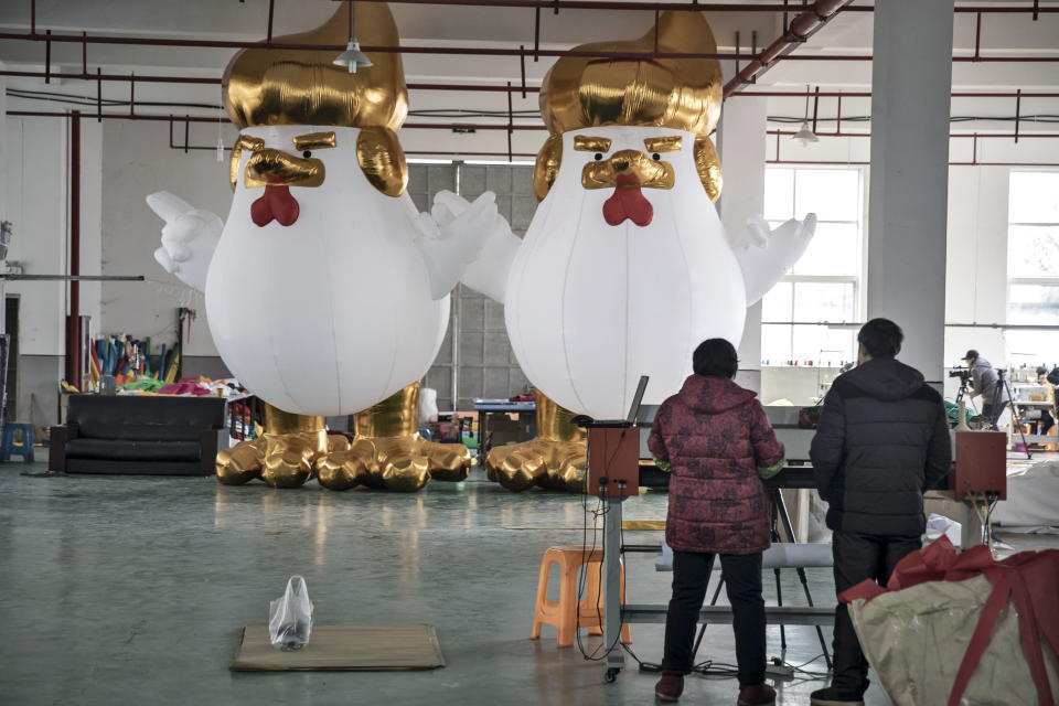 Workers stand in front of inflatable chickens, bearing a likeness to U.S. President-elect Donald Trump and produced ahead of the Lunar New Year of the Rooster, at a Caile Inflatables Products Co. factory in Jiaxing, China, on Thursday, Jan. 12, 2017. Photographer: Qilai Shen/Bloomberg via Getty Images