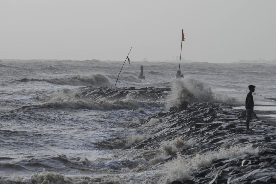 A boy walks as high tide waves hit the Arabian Sea coast at Juhu Koliwada in Mumbai, India, Monday, June 12, 2023. Cyclone Biparjoy, the first severe cyclone in the Arabian Sea this year is set to hit the coastlines of India and Pakistan Thursday. (AP Photo/Rafiq Maqbool)