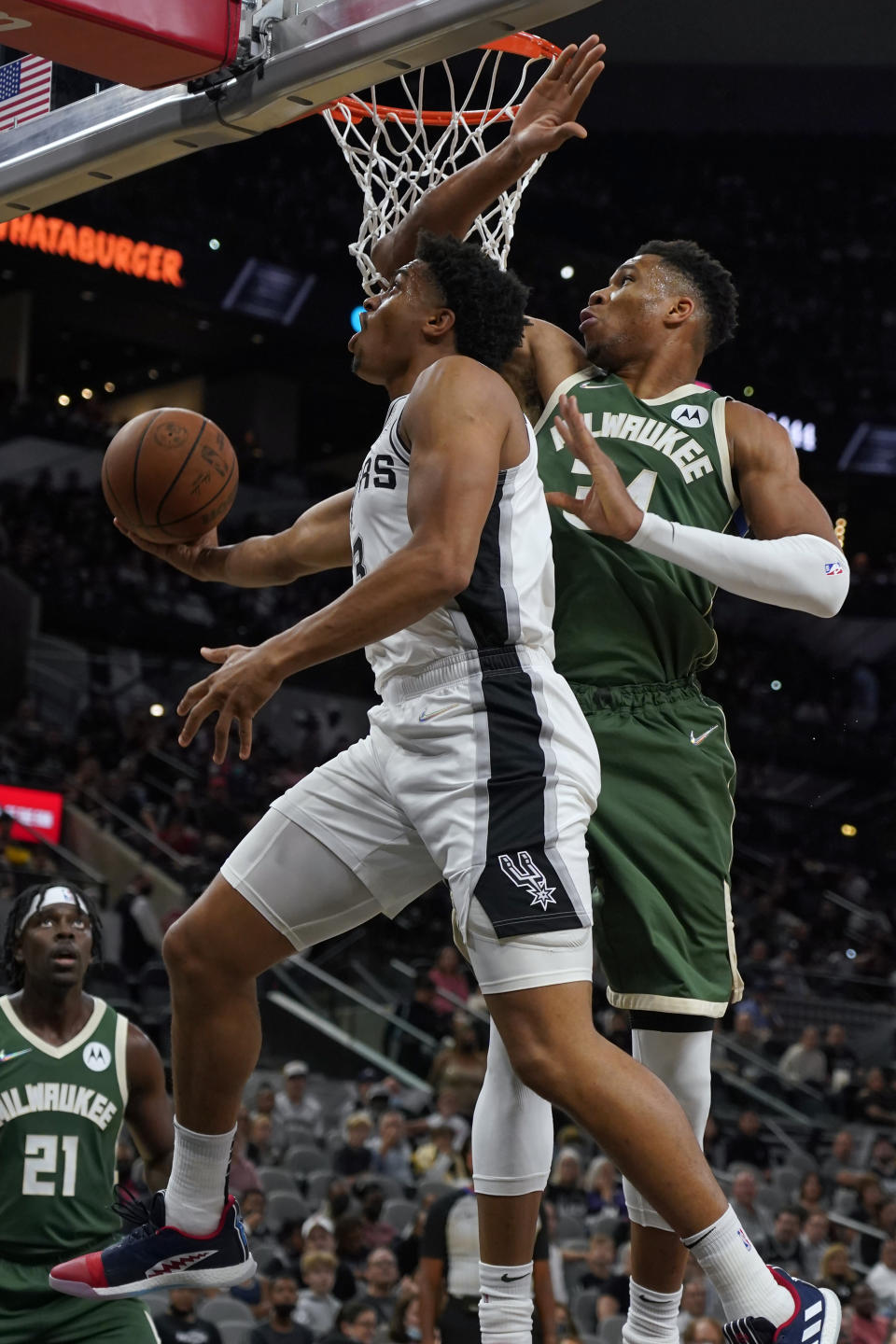 San Antonio Spurs' Keldon Johnson (3) drives past Milwaukee Bucks' Giannis Antetokounmpo (34) during the first half of an NBA basketball in San Antonio, Texas, Saturday, Oct. 23, 2021. (AP Photo/Chuck Burton)