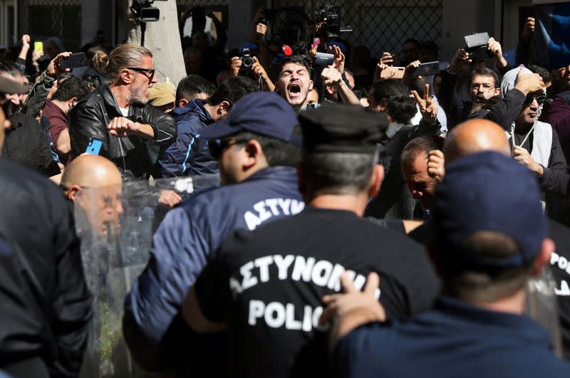 Turkish Cypriots scuffle with Greek Cypriot police officers at the Ledra checkpoint of the U.N.-controlled buffer zone, after authorities declared the crossing temporarily shut to curb any potential spread of coronavirus, in Nicosia