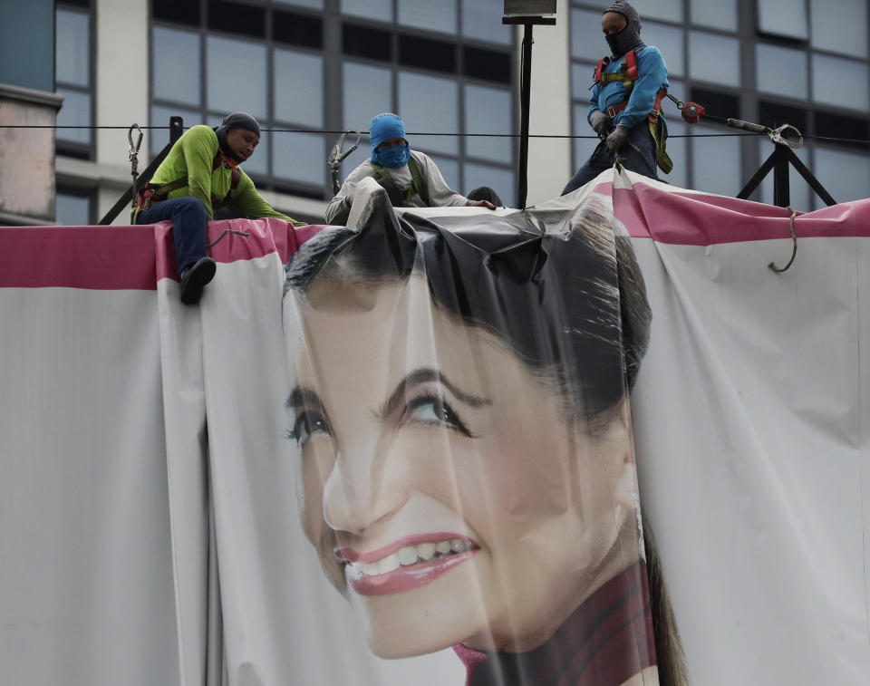 Workers fold up a billboard to prepare for the coming of typhoon Vongfong, in Manila, Philippines on Thursday May, 14, 2020. The first typhoon to hit the country this year roared toward the eastern Philippines on Thursday as authorities work to evacuate tens of thousands of people while avoiding overcrowding in shelters that could spread the coronavirus. (AP Photo/Aaron Favila)