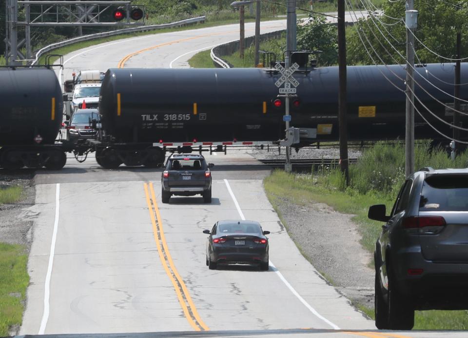 Motorists wait for a train at the Hines Hill Railroad crossing last summer. Signs will be installed this summer both east and west of the tracks to warn motorists when a train is stopped at this crossing.