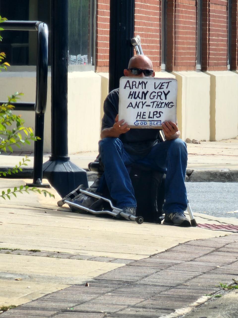 A homeless veteran is seen at the corner of Union and Davis streets.