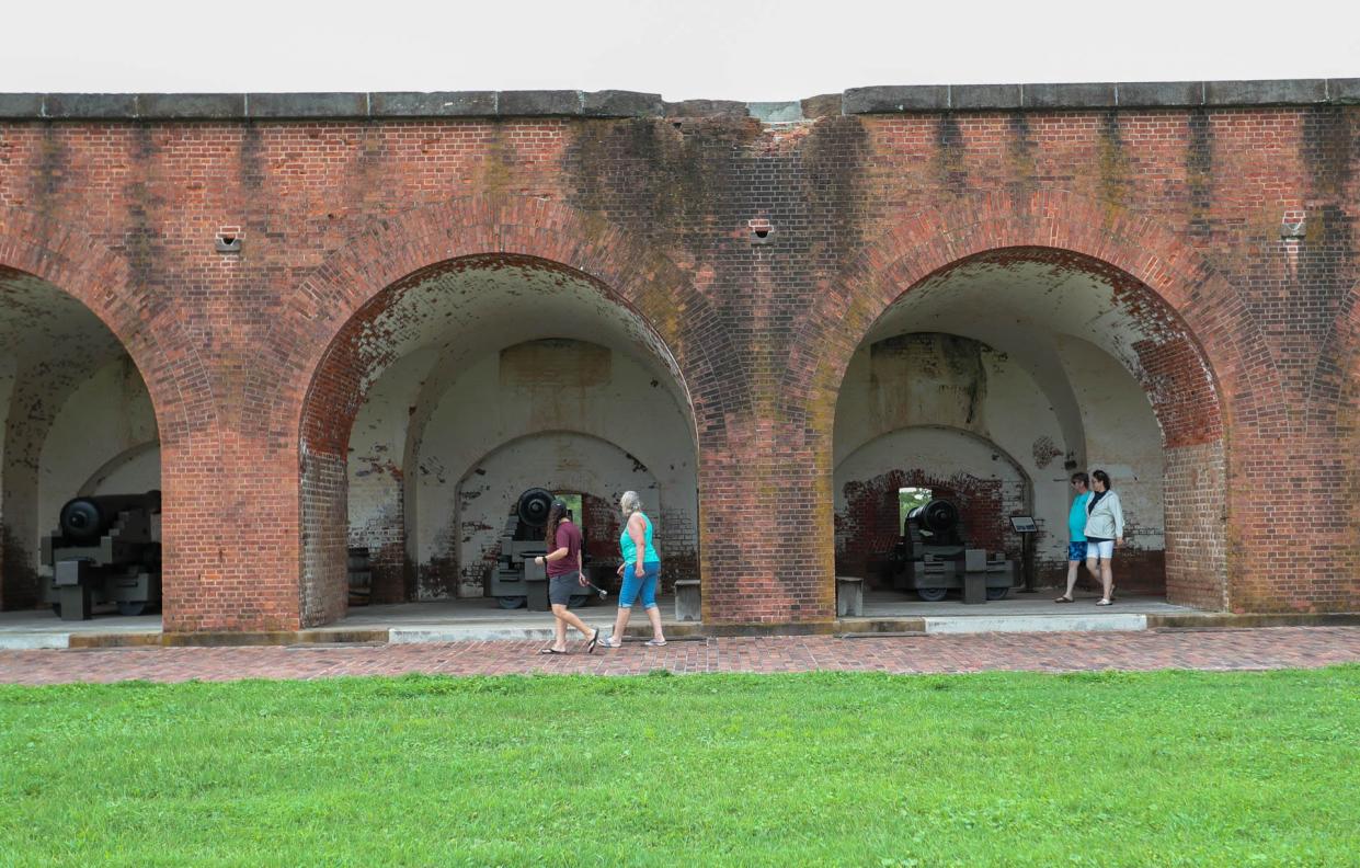 Visitors walk around a cannon at Fort Pulaski National Monument.