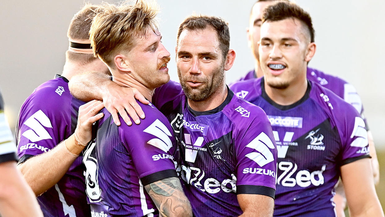 Cameron Smith (pictured middle) celebrates with Cameron Munster (pictured left) after a try.