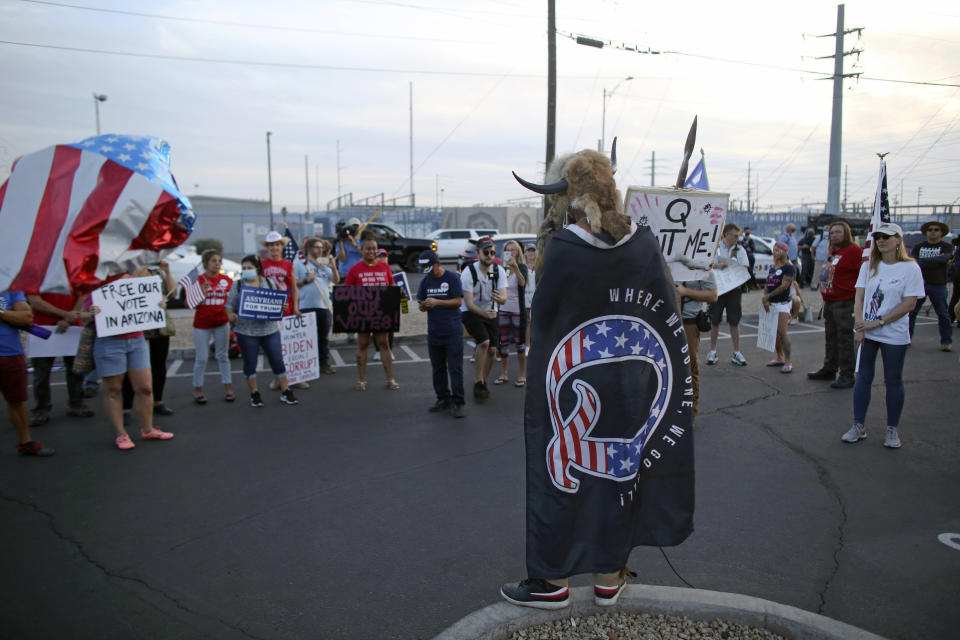 FILE - In this Thursday, Nov. 5, 2020, file photo, a QAnon believer speaks to a crowd of President Donald Trump supporters outside of the Maricopa County Recorder's Office where votes in the general election are being counted, in Phoenix. Ron Watkins, a prolific promoter of false conspiracies about the 2020 election who is closely tied to the QAnon movement, says he's running for Congress as a Republican in Arizona. (AP Photo/Dario Lopez-MIlls, File)