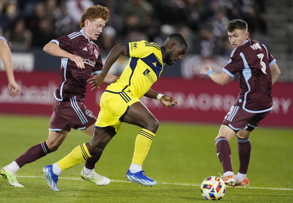 Nashville SC defender Laurence Wyke, center, struggles to control the ball as Colorado Rapids midfielder Oliver Larraz, left, and defender Sam Vines, right, cover during the first half of an MLS soccer match Saturday, March 2, 2024, in Commerce City, Colo. (AP Photo/David Zalubowski)