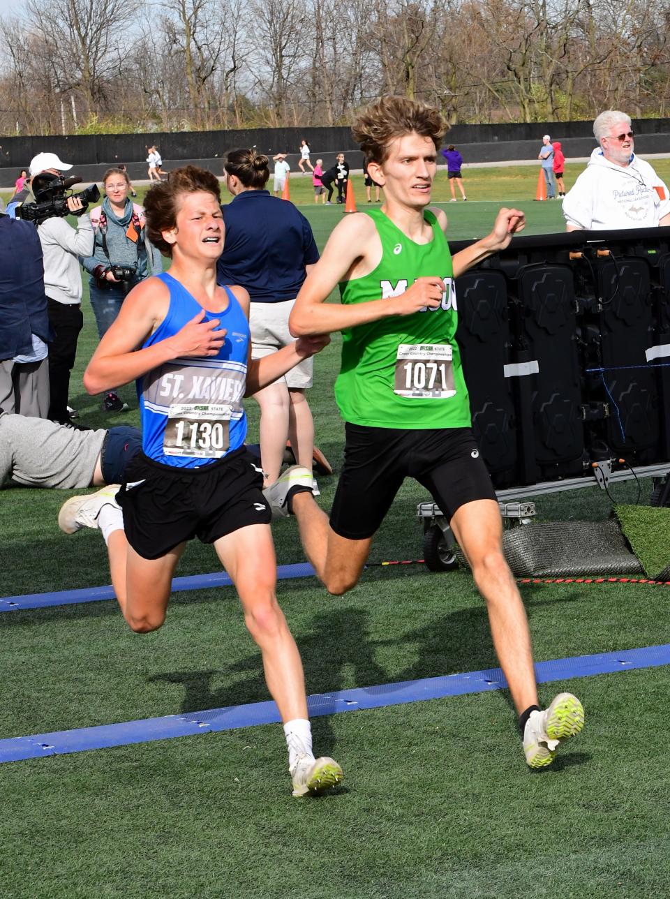 Luke Fox of St. Xavier and Braeden Fedders of Mason cross the finish line neck-n-neck in the Division I boys race at the OHSAA state cross-country championships, Nov. 5, 2022.
