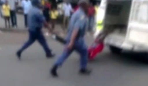 A grab from an amateur video released by South Africa's Daily Sun shows a man handcuffed to a police van and dragged through the streets in Daveyton, on February 28, 2013