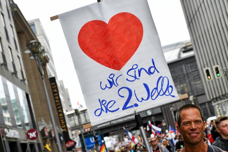 Ein Teilnehmer hält ein Schild "Wir sind die 2. Welle" in der Friedrichstraße bei einer Demonstration gegen die Corona-Maßnahmen.<span class="copyright">Paul Zinken / dpa</span>