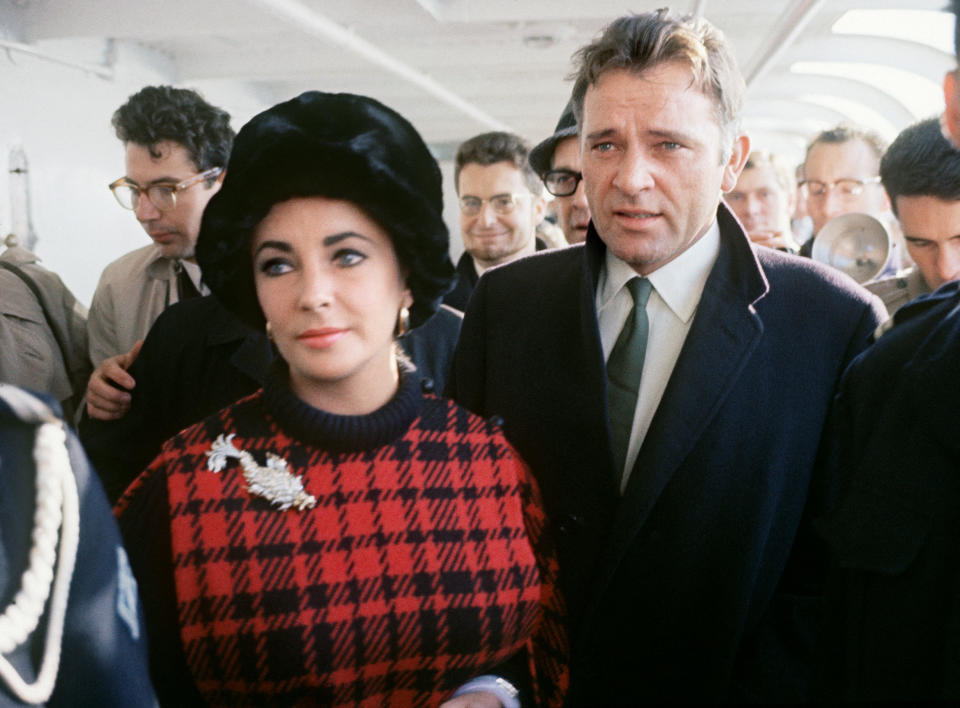 US actress Elizabeth Taylor (L) and her husband British actor Richard Burton are seen on the Transporter bridge in Cherbourg on October 12, 1964 during a trip in France. (Photo by – / AFP) (Photo by -/AFP via Getty Images)