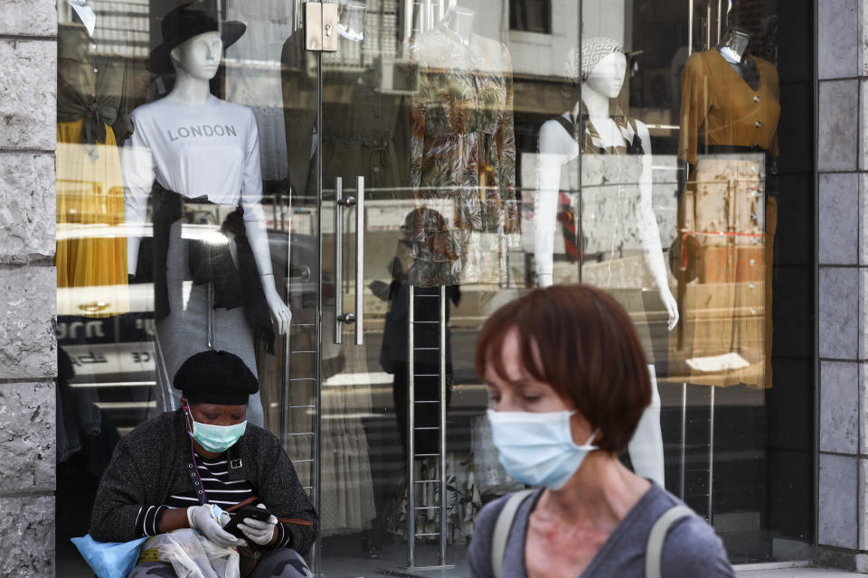 People wear protective face masks on a mainly deserted street because of the government's measures to help stop the spread of the coronavirus, in Bnei Brak, a suburb of Tel Aviv, Israel, Friday, April 3, 2020. By Friday, Bnei Brak had become the country's worst hot spot and now resembles a ghost town. (AP Photo/Oded Balilty)