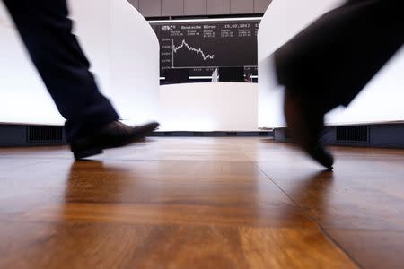 A trader walks past the German DAX Index board on the trading floor at the Frankfurt stock exchange in Frankfurt, Germany, February 15, 2017. REUTERS/Ralph Orlowski