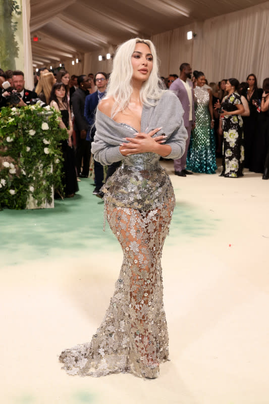 <p>Photo by John Shearer/WireImage</p><p>Kardashian showed up to the latest Met Gala in a Maison Margiela corset and a John Galliano cardigan. Some critics <a href="https://parade.com/news/critics-slam-kim-kardashian-setting-gross-beauty-standard-impossibly-tiny-corset-dress-met-gala-2024" rel="nofollow noopener" target="_blank" data-ylk="slk:slammed the look;elm:context_link;itc:0;sec:content-canvas" class="link rapid-noclick-resp">slammed the look</a> for setting an impossible (and dangerous) beauty standard. </p>