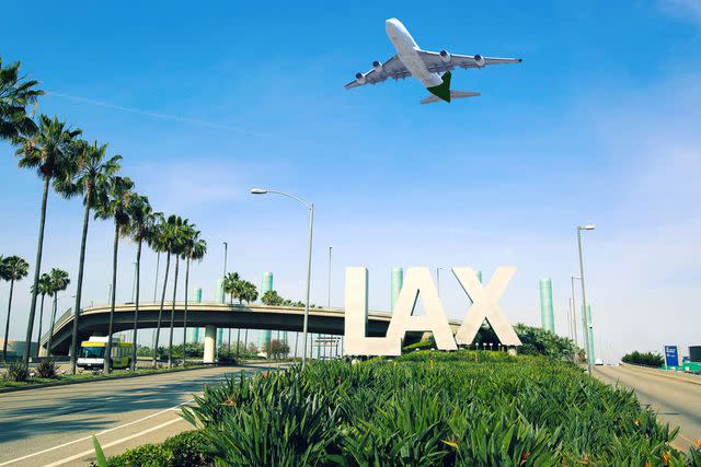 <p>Getty</p> Los Angeles Airport sign full highway with airplane flying