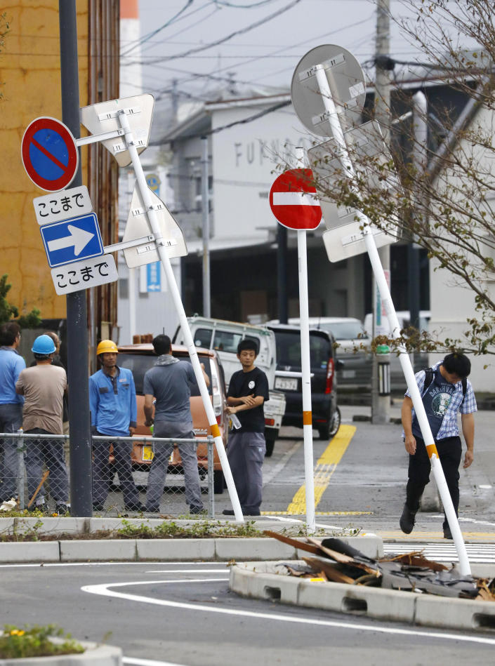 In this Sunday, Sept. 22, 2019, photo, road signs lean after strong winds brought about by Typhoon Tapah swept Nobeoka, Miyazaki prefecture, southwestern Japan. The powerful typhoon lashed parts of Japan's southern islands with heavy rains and winds that caused flooding and some minor injuries. (Takuto Kaneko/Kyodo News via AP)