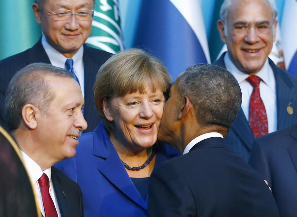 U.S. President Barack Obama kisses German Chancellor Angela Merkel as members of the Group of 20 prepare for the traditional family photo during the G20 leaders summit in the Mediterranean resort city of Antalya, Turkey, on Nov. 15, 2015.