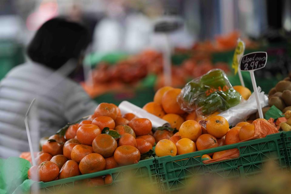 FILE - A woman looks at fruit and vegetables on sale at a stall in London, Tuesday, Feb. 28, 2023. Inflation across the U.K. fell unexpectedly in August to its lowest level since Russia launched its invasion of Ukraine, raising hopes that the Bank of England may pause interest rate hikes after another one on Thursday. It said that lower hotel and air fare costs and a moderation in food price rises. (AP Photo/Alastair Grant, File)