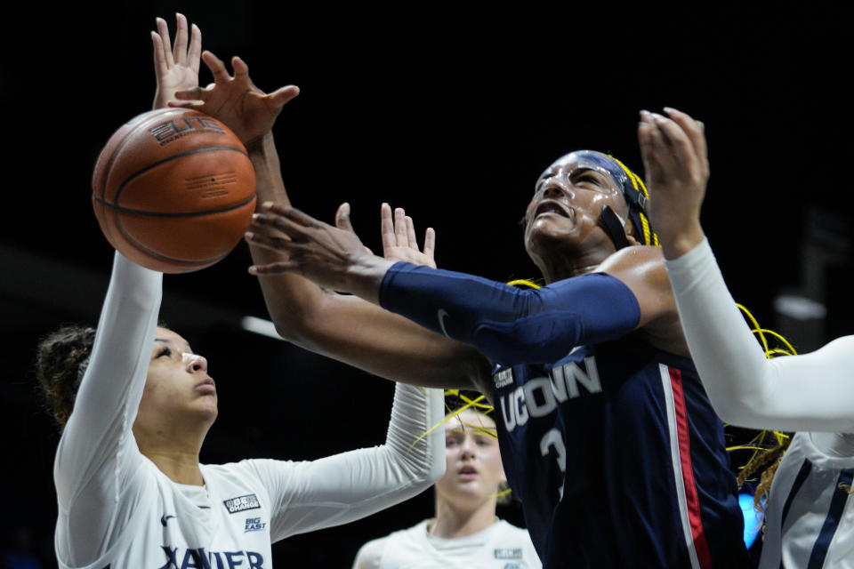 UConn forward Aaliyah Edwards (3) is fouled by Xavier's Shelby Calhoun, left, as she shoots during the first half of an NCAA college basketball game, Thursday, Jan. 5, 2023, in Cincinnati. (AP Photo/Jeff Dean)