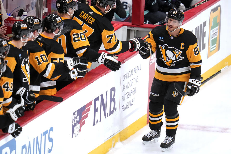 Pittsburgh Penguins' Sidney Crosby (87) returns to the bench after his empty-net goal during the third period of an NHL hockey game against the Seattle Kraken in Pittsburgh, Monday, Jan. 15, 2024. It was Crosby's second goal of the game. (AP Photo/Gene J. Puskar)