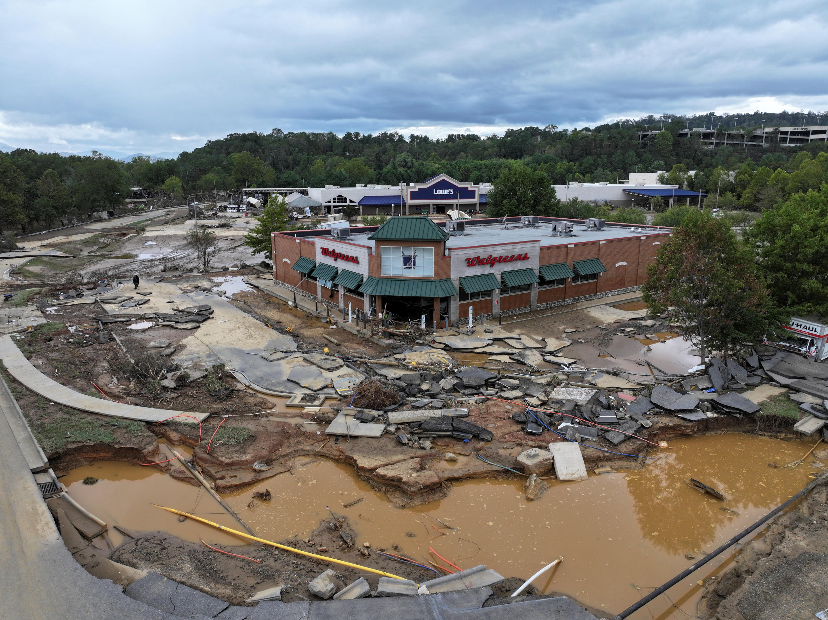 A drone view shows debris and standing water near a Walgreens.