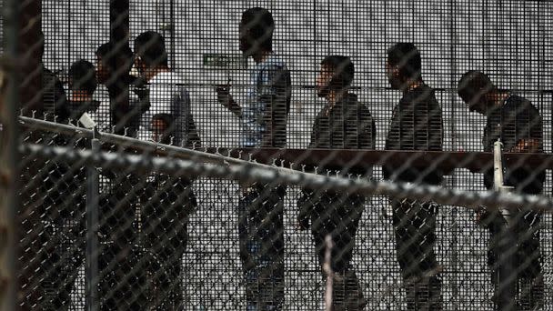 PHOTO: Migrants wait in along the border wall to board a bus after surrendering to US Customs and Border Protection (CBP) Border Patrol agents for immigration and asylum claim processing on the US-Mexico border in El Paso, Texas, May 12, 2023. (Patrick T. Fallon/AFP via Getty Images)