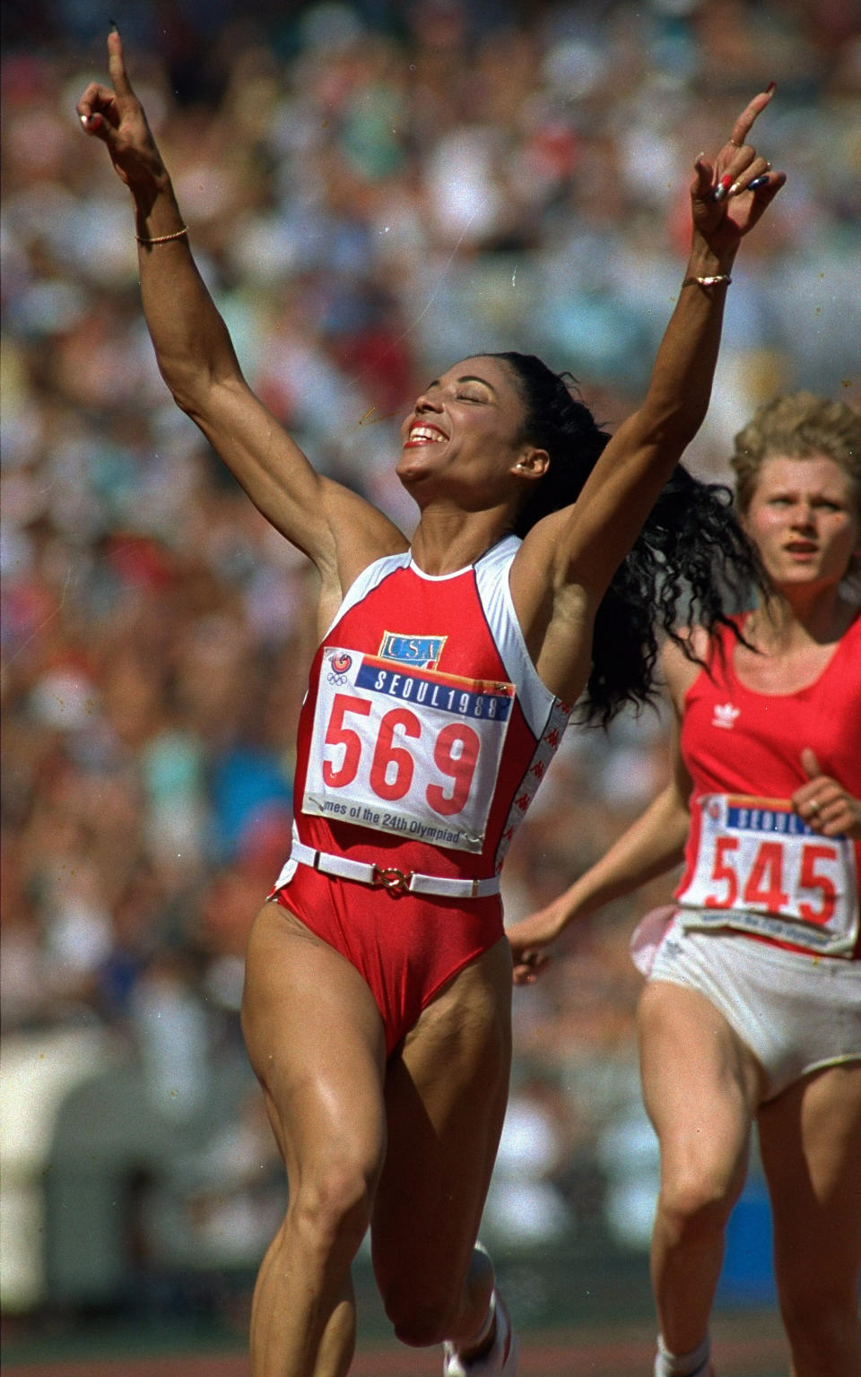 FILE - In this Sept. 25, 1988, file photo, Florence Griffith-Joyner celebrates her victory in the 100-meter dash at the 1988 Olympic Games in Seoul, South Korea. She was clocked at 10.54 seconds, to break an Olympic record. Behind her is Natalia Pomoshchnikova of the Soviet Union, who finished sixth in the race. (AP Photo/Dieter Endlicher, File)