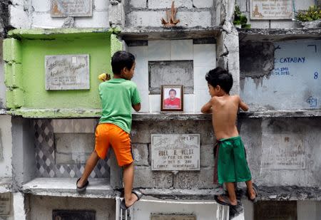 Boys look at the tomb of Michael Almeda, who was among those allegedly killed by the Bonnet Gang, in more than 60 drug-related vigilante killings in the town of Pateros, Metro Manila, Philippines March 15, 2017. REUTERS/Erik De Castro