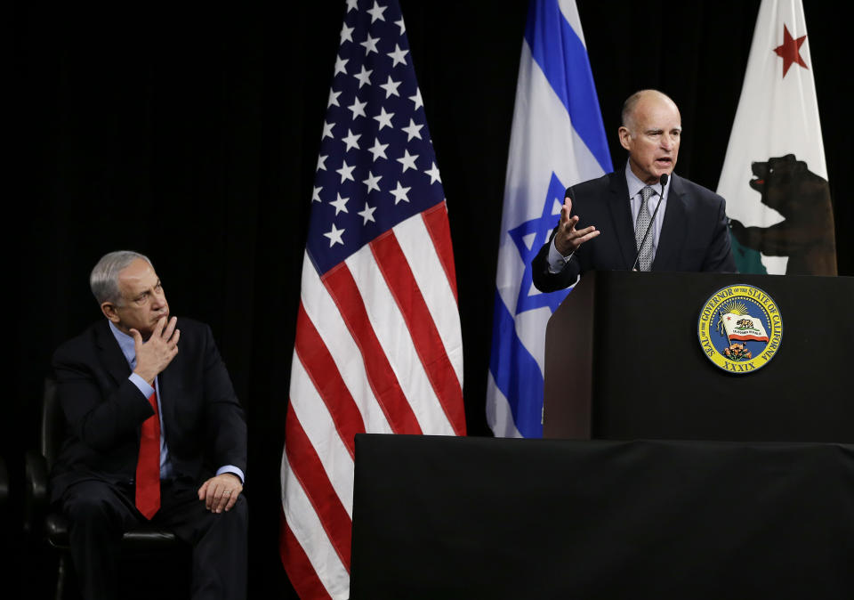 Israeli Prime Minister Benjamin Netanyahu, left, listens to California Gov. Jerry Brown, right, speak before the signing of an agreement to expand cooperation at the Computer History Museum Wednesday, March 5, 2014, in Mountain View, Calif. Netanyahu is visiting California, trading a focus on the geopolitics of the Middle East for a Hollywood screening and visits with Silicon Valley tech entrepreneurs.(AP Photo/Eric Risberg)