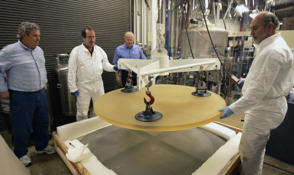 FILE - In this Jan. 7, 2008, file photo, Thirty Meter Telescope Project Scientist Jerry Nelson, left, and Telescope Optics Group Leader Eric Williams, third from left, inspect a 500 pound glass blank as it is removed from packing by Dave Hilyard, Chief Optician at University of California, right, and Brian Dupraw at the UC Observatory Optical Lab at the University of California at Santa Cruz, Calif. Hawaii officials are demobilizing law enforcement at a mountain where protesters are blocking construction of a giant telescope because the project isn't moving forward for now. An international consortium wants to build the Thirty Meter Telescope on Mauna Kea, Hawaii's tallest peak. But some Native Hawaiians believe the telescope will desecrate sacred land. Protesters have stopped construction from going forward since mid-July. (AP Photo/Ben Margot, File)