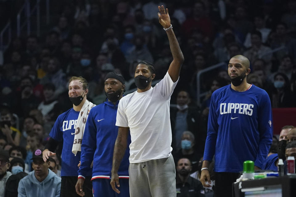 Los Angeles Clippers' Paul George, center, celebrates after a 3-pointer during the first half of an NBA basketball game against the Boston Celtics in Los Angeles, Wednesday, Dec. 8, 2021. (AP Photo/Ashley Landis)