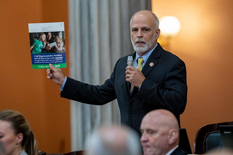 Rep. J. Kyle Koehler shows a flyer that put pressure on him to vote for HB6 as he speaks in favor of a resolution to expel Rep. Larry Householder during a session of the Ohio House at the Ohio Statehouse on June 16, 2021.