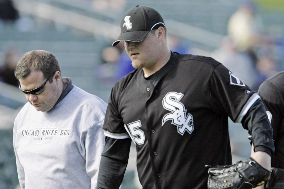 Chicago White Sox pitcher Bobby Jenks leaves the mound in the fifth inning with assistant trainer Brian Ball during a spring training baseball game against the Colorado Rockies on Feb. 28, 2007 in Tucson, Ariz. Ball, a former athletic trainer for the White Sox, is alleging in a lawsuit that he was fired by the team because of his sexual orientation, age and disability. In a team statement, the White Sox described Ball's allegations as “baseless” and promised to vigorously defend the organization's reputation. (AP Photo/M. Spencer Green, File)