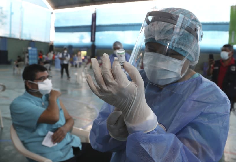 A nurse prepares a dose of China's Sinopharm vaccine during a priority COVID-19 vaccination of health workers at a public hospital in Lima, Peru, Wednesday, Feb. 10, 2021. Peru received its first shipment of COVID-19 vaccines on Sunday night. (AP Photo/Martin Mejia)