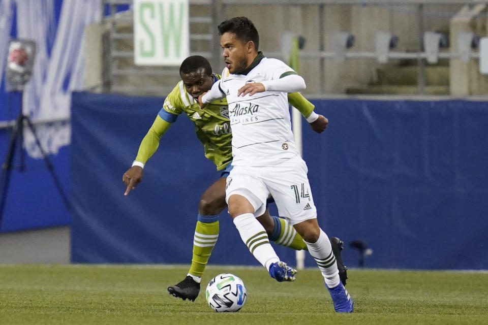 Portland Timbers' Andres Flores (14) dribbles in front of Seattle Sounders' Nouhou in the first half of an MLS soccer match Thursday, Oct. 22, 2020, in Seattle. (AP Photo/Elaine Thompson)