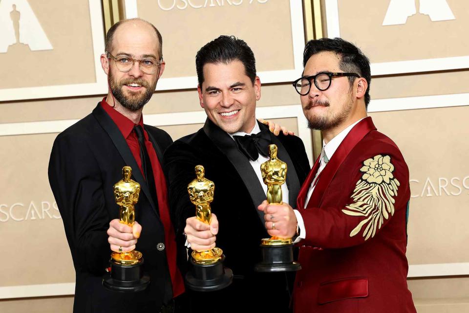 <p>Arturo Holmes/Getty Images</p> (L-R) Daniel Scheinert, winner of the Best Director award, Jonathan Wang, winner of the Best Picture award and Dan Kwan winner of the Best Director award for "Everything Everywhere All at Once," pose in the press room during the 95th Annual Academy Award