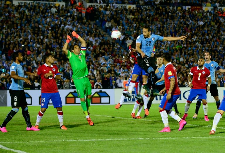 Uruguay's Martin Caceres (22) heads the ball to score against Chile during their Russia 2018 FIFA World Cup South American Qualifiers football match, in Montevideo, on November 17, 2015