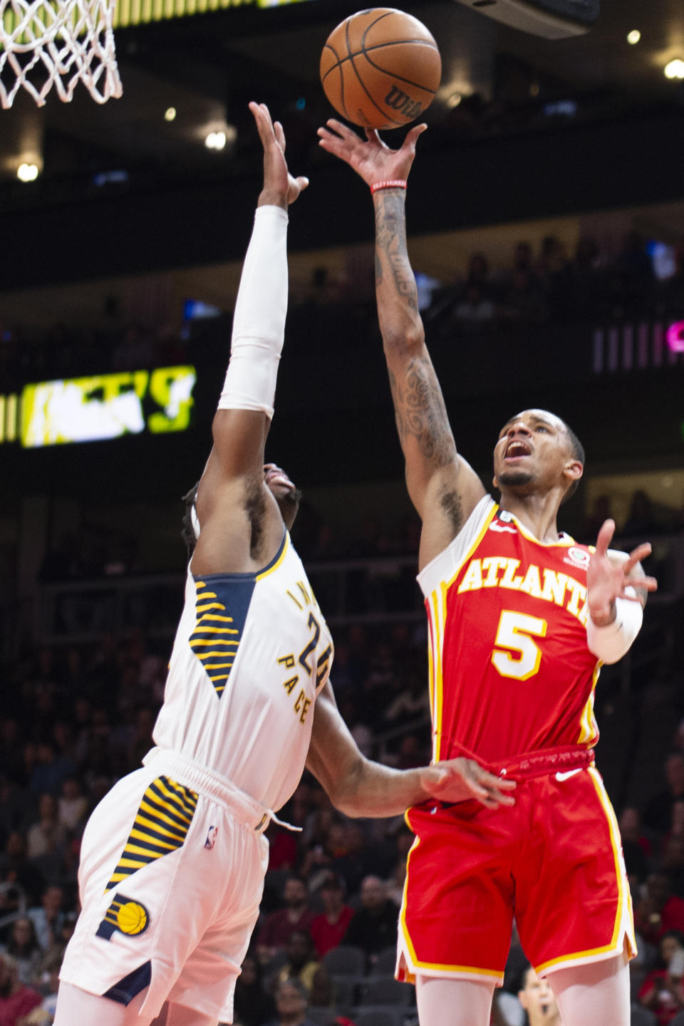 Atlanta Hawks guard Dejounte Murray shoots over Indiana Pacers guard Buddy Hield during the first half of an NBA basketball game, Saturday, March 25, 2023, in Atlanta. (AP Photo/Hakim Wright Sr.)