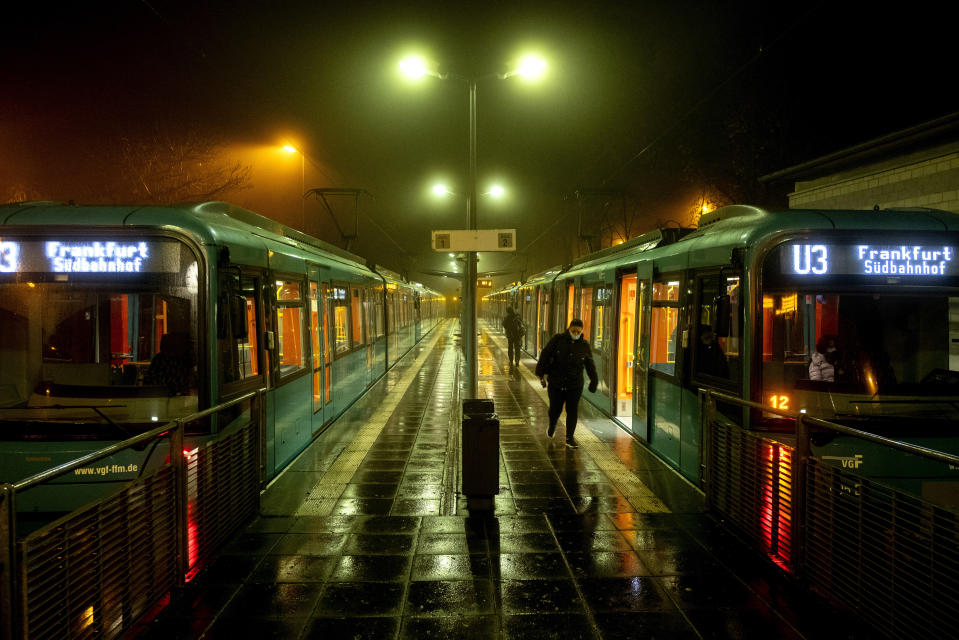 FILE - In this Thursday, Nov. 12, 2020 file photo, a woman walks away from a subway station in Oberursel near Frankfurt, Germany, as the numbers of new Coronavirus infections went over 20,000 again. More than 50,000 people have died after contracting COVID-19 in Germany, a number that has risen swiftly over recent weeks as the country has struggled to bring down infection figures. (AP Photo/Michael Probst, file)