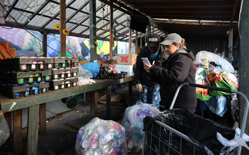 Rosa Rosario, right, works with canner Chicago Crosby as they calculate her total haul at Sure We Can, a non-profit recycling center, community space and sustainability hub in Brooklyn, photographed Nov. 16, 2023.