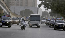 Police commandos escort a mini-bus carrying South Africa's cricket team arriving for a practice session at the National Cricket Stadium, in Karachi, Pakistan, Saturday, Jan. 23, 2021. South Africa, which arrived in the southern port city of Karachi for the first time in nearly 14 years, will play the first test match against Pakistan starting on Jan. 26. (AP Photo/Fareed Khan)