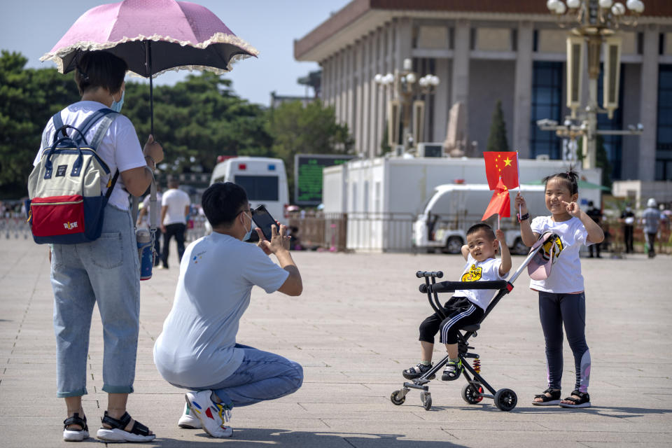 Children hold Chinese flags as they pose for a photo at Tiananmen Square in Beijing, on June 22, 2021. China will now allow couples to have a third child as the country seeks to hold-off a demographic crisis that threatens its hopes of increased prosperity and global influence. (AP Photo/Mark Schiefelbein)