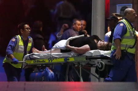 Paramedics remove an injured woman on a stretcher from the Lindt cafe, where hostages were being held, at Martin Place in central Sydney December 16, 2014. REUTERS/David Gray