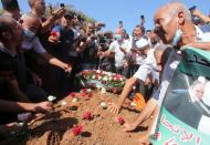 People put roses at the burial site of former Algerian President Abdelaziz Bouteflika at El Alia cemetery, in Algiers